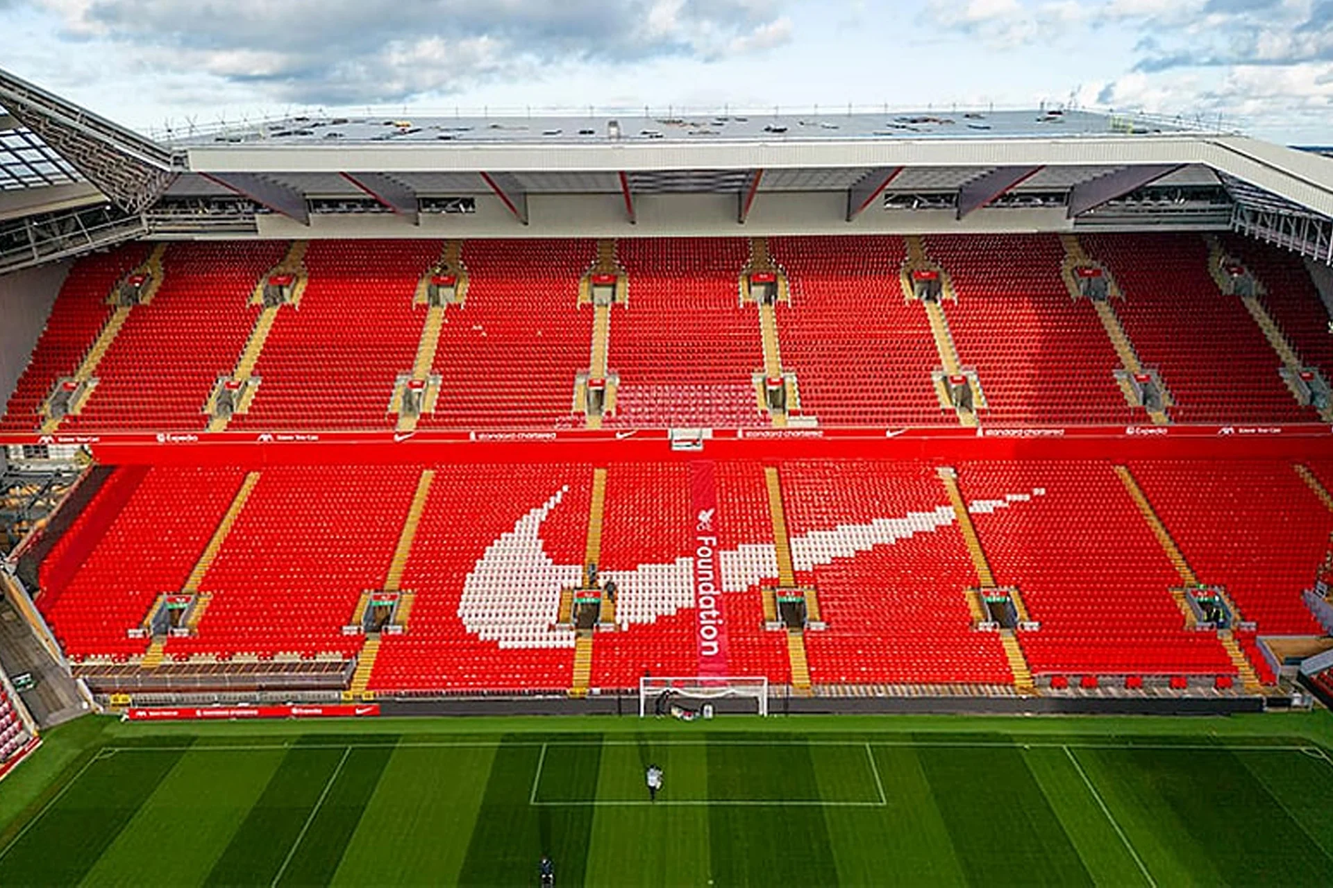 عرض مقاعد مدرج آنفيلد في ملعب ليفربول FC مع مقاعد حمراء ونمط شعار LFC.