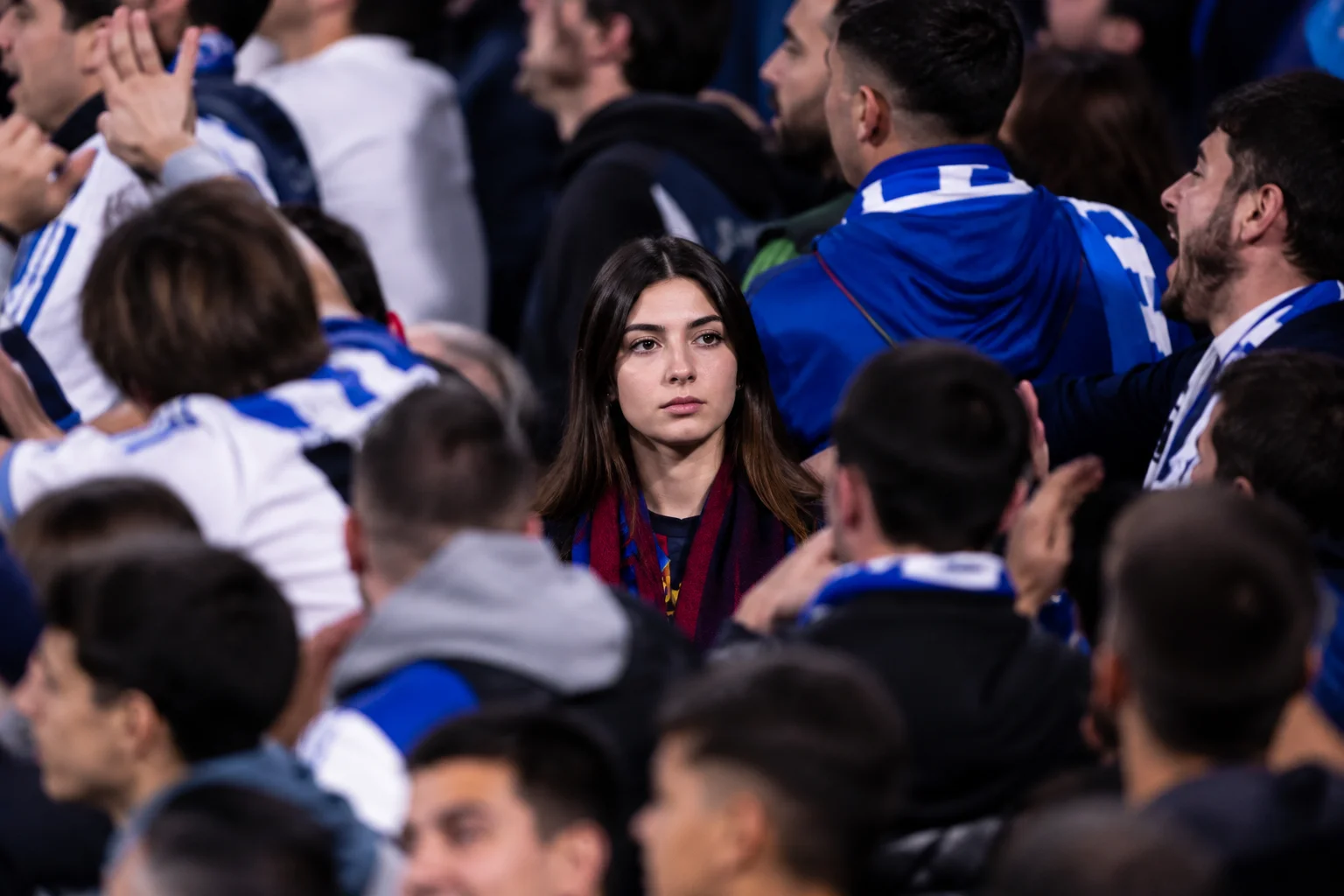 An advisory graphic titled "Don't End Up in the Away Section" provides critical ticketing advice for fans. The main background shows a crowd of football supporters dressed in matching colors celebrating in a stadium tier. Two major text sections dominate the infographic. The left section, "Mistaken Identity," warns fans to be incredibly careful when purchasing tickets via third-party resale sites, as it is easy to accidentally buy a seat in the designated away fans section. The right section, "The Consequences," explicitly notes that if you wear home team colors or openly celebrate a home team goal while sitting in the away section, you will be swiftly ejected by stadium stewards for your own personal safety.
