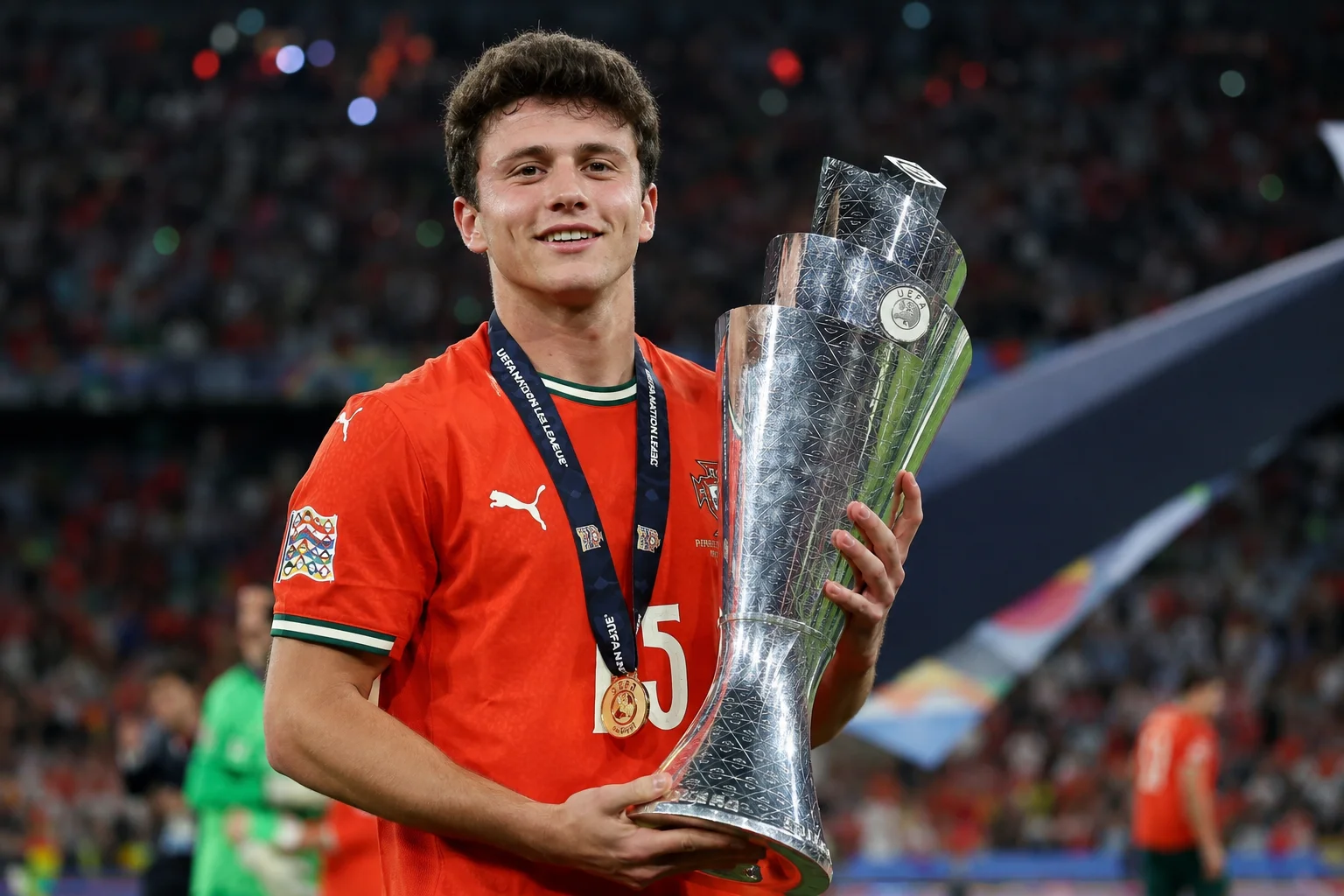 صورة للاعب الوسط البرتغالي جواو نيفيس منتصف المباراة. يظهر من الصدر إلى الأعلى، ينظر بشكل مباشر للأمام بتعبير متنبه ومركز. يرتدي القميص الأحمر الكلاسيكي للبرتغال مع ياقة منظمة باللون الأخضر والأسود. الخلفية تتضمن الأعشاب الخضراء المتألقة والتي تم طمسها بشكل ناعم ومدرجات بعيدة.