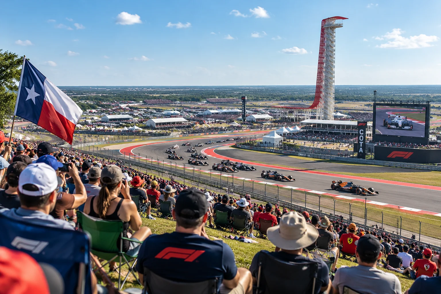 Spectators seated on a grassy hillside at Circuit of the Americas watching Formula 1 race cars navigate a turn with a Texas flag waving.